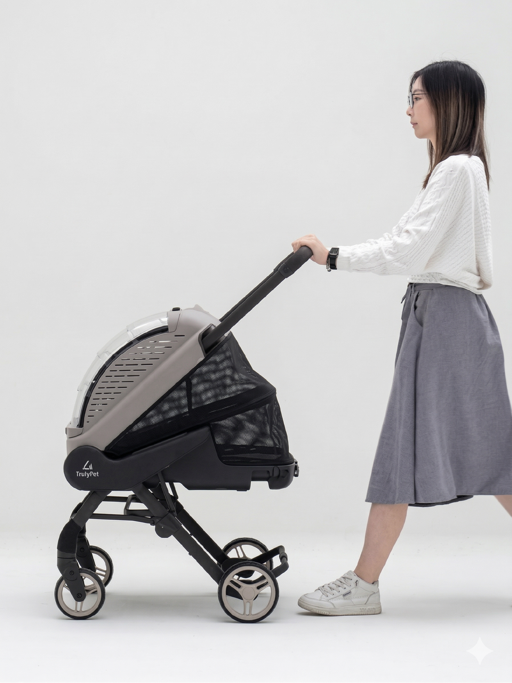 Woman pushing the TrulyPet Explorer pet stroller, studio photograph
